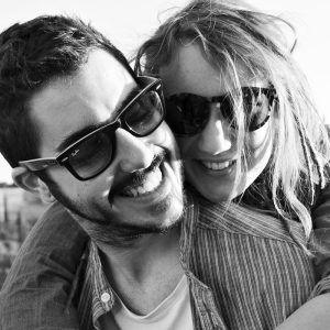 Una alegre pareja se abraza, con gafas de sol en una fotografía en blanco y negro tomada durante "Un paseo de fotografía en pareja en Granada. - ForTwo - Planes para parejas