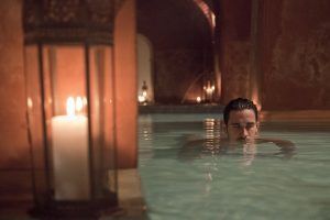 En medio de una piscina tenuemente iluminada y velas parpadeantes, uno se encuentra envuelto en un ambiente sereno similar al Baño y masaje individual MIDRA 30 en Hammam Al Ándalus Madrid. - ForTwo - Planes para parejas