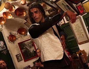 Una persona con chaleco blanco realiza un encantador baile flamenco como el Espectáculo de flamenco en la Zambra María la Canastera, en una acogedora sala con ollas de cobre colgantes. - ForTwo - Planes para parejas