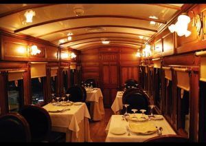 Restaurante El Vagón de Beni ofrece una lujosa experiencia gastronómica en un tren clásico de Madrid, con mesas elegantemente dispuestas e iluminación cálida. - ForTwo - Planes para parejas