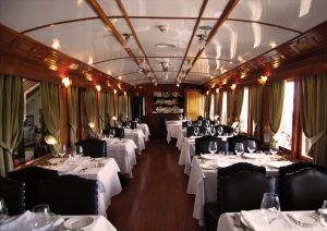Experimente el Restaurante El Vagón de Beni, un vagón restaurante de tren clásico en Madrid que irradia romance con sus elegantes interiores con manteles blancos, cortinas verdes y madera pulida. - ForTwo - Planes para parejas