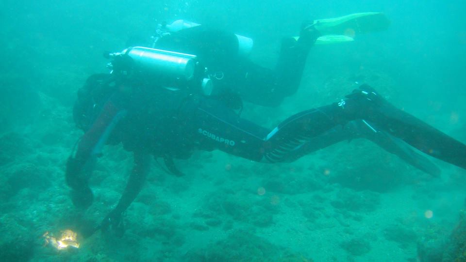Un buzo, equipado con equipo y aletas, explora el fondo del océano en un emocionante "Paquete experiencia escapada de buceo en la costa de Granada". - ForTwo - Planes para parejas