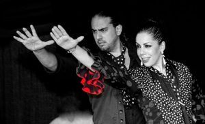 Dos bailarinas vestidas de flamenco en poses dramáticas capturan la esencia vibrante de un "Espectáculo de flamenco en los Jardines de Zoraya". - ForTwo - Planes para parejas