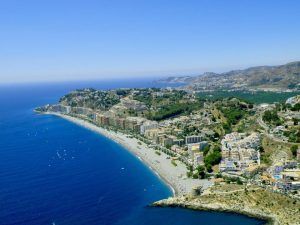 Experimente vistas impresionantes con un recorrido en helicóptero sobre el encanto del sur de Granada, con paisajes urbanos costeros, aguas cristalinas, playas de arena y colinas circundantes bajo un cielo despejado. - ForTwo - Planes para parejas