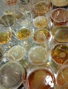 Vasos de cerveza llenos de diferentes tonos de cerveza sobre una superficie reflectante evocan la atmósfera vibrante del Taller de cata y degustación de cerveza en Barcelona. - ForTwo - Planes para parejas