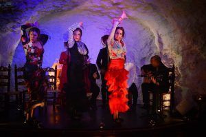 En un entorno tipo cueva, El Templo del Flamenco deslumbra con vibrantes bailarines que actúan al ritmo de un guitarrista, creando un espectáculo inolvidable. - ForTwo - Planes para parejas