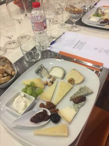 Disfrute de un "Taller de cata y degustación de quesos artesanos en Barcelona", con una tabla de quesos con frutos secos, uvas y mermelada, perfectamente combinada con copas de vino y notas de cata para una experiencia encantadora. - ForTwo - Planes para parejas