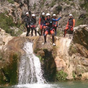 Los aventureros disfrutan del Barranquismo en Granada - Barranco de Lentegí completo mientras un alma atrevida se lanza al río, rodeado de exuberante vegetación y acantilados imponentes. - ForTwo - Planes para parejas