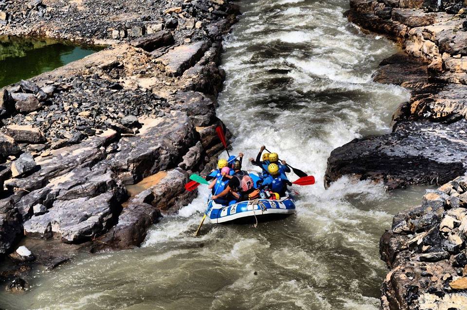 Los aventureros experimentan la emoción del "Rafting en Granada - Canal de aguas bravas", maniobrando expertamente a través de un estrecho y rocoso canal de río con una hábil navegación a remo. - ForTwo - Planes para parejas
