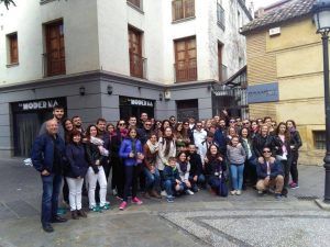 Un gran grupo de personas sonriendo y posando frente a los pintorescos edificios del Albaicín captura la esencia de #FeelTheCity durante el Tour por el Albaicín y Sacromonte de FeelTheCity. - ForTwo - Planes para parejas