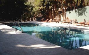 Relájese en la tranquilidad del Balneario de Lanjarón con nuestra piscina al aire libre, rodeada de frondosos árboles y una vibrante pared verde. Disfrute de un ambiente sereno después de su circuito de aguas saludables, todo desde la comodidad de su espaciosa habitación doble. - ForTwo - Planes para parejas
