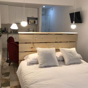 Acogedor dormitorio en "Apartamento para 2 en el centro de Granada", con cama de matrimonio con cabecero de madera y zona de cocina, suavemente iluminada por lámparas colgantes, situado en el centro de Granada. - ForTwo - Planes para parejas
