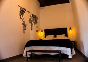 Apartamento para 2 en el centro de Granada cuenta con un acogedor dormitorio con una temática en blanco y negro, resaltado por un intrigante mapa del mundo sobre la cama. - ForTwo - Planes para parejas