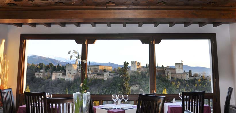 Estrellas de San Nicolás ofrece una experiencia gastronómica mágica con vistas panorámicas a la Alhambra a través de grandes ventanales, perfectamente ambientados con mesas y sillas para una "Cena para dos". - ForTwo - Planes para parejas