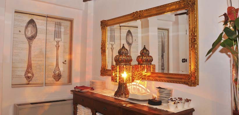 El Restaurante Estrellas de San Nicolás ofrece un acogedor comedor adornado con un espejo adornado, una lámpara decorativa, platos apilados y utensilios de arte, ideal para una romántica "Cena para dos con vistas a la Alhambra". - ForTwo - Planes para parejas