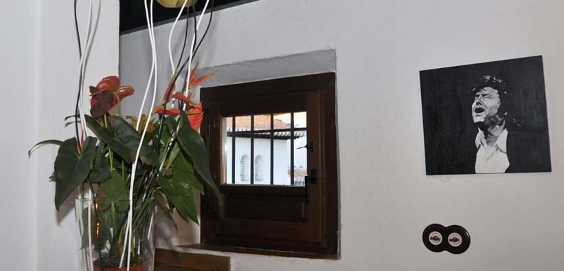 Una pequeña ventana con rejas, un jarrón de flores y un retrato en blanco y negro crean el encanto atemporal de la "Cena para dos con vistas a la Alhambra" en Estrellas de San Nicolás. - ForTwo - Planes para parejas