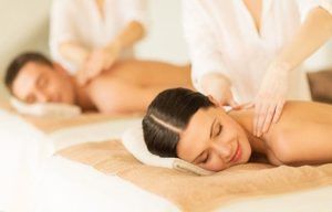 Un hombre y una mujer se relajan con el Masaje Mindfulness para 2 personas en Granada, tumbados en camas de spa con toallas blancas, disfrutando de una experiencia consciente. - ForTwo - Planes para parejas