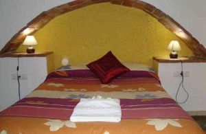 Experimente Una noche romántica en cueva de turismo rural (Guadix) en un acogedor dormitorio con techo de ladrillo arqueado, colcha colorida y lámparas de noche, perfecto para el corazón del encantador entorno de Guadix. - ForTwo - Planes para parejas