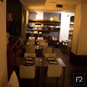 El Restaurante Ruta del Azafrán cuenta con un interior encantador con mesas listas para comer, iluminación tenue y estantes decorativos. Disfrute del ambiente mientras explora el delicioso Menú Sabores en Restaurante Ruta del Azafrán frente a la Alhambra. - ForTwo - Planes para parejas