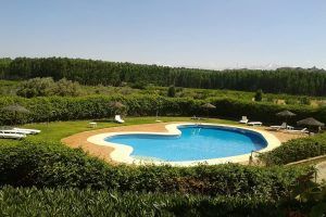 Ubicado en un pintoresco paisaje boscoso, disfrute de Dos noches en cueva romántica con hammam y masaje (Guadix), que cuenta con una piscina en forma de corazón rodeada de follaje verde, tumbonas y sombrillas para una escapada de relajación perfecta. - ForTwo - Planes para parejas