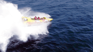 La lancha rápida "Surca las olas a toda velocidad en Chicken Boat en Barcelona" corta con destreza las olas del océano, creando un gran chapoteo a medida que acelera. - ForTwo - Planes para parejas