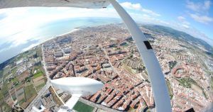 Vista aérea desde un vuelo en avión en Barcelona sobre el paisaje urbano con costa, extensas áreas urbanas y campos verdes. - ForTwo - Planes para parejas