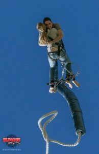 Dos personas se abrazan durante la emocionante experiencia de Puenting o Salto Bungee Jumping para parejas en Barcelona, con un cielo azul claro como fondo. - ForTwo - Planes para parejas
