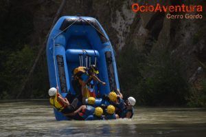 Un grupo de aventureros con cascos navega con destreza las emocionantes aguas del Río Genil a bordo de una balsa inflable, que se desplaza verticalmente entre las salvajes Aguas Bravas. - ForTwo - Planes para parejas
