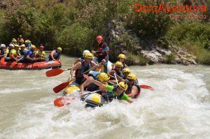 Los participantes, equipados con cascos y chalecos salvavidas, navegan por los rápidos del Río Genil, guiados expertamente por un instructor de Aguas Bravas. - ForTwo - Planes para parejas