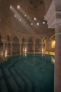 El exclusivo MIDRA en Hammam Al Ándalus Málaga ofrece una serena piscina cubierta con columnas arqueadas, luces de techo estrelladas y paredes de azulejos estampados para un ambiente único de relajación. - ForTwo - Planes para parejas
