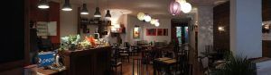 El Restaurante La Luz de la Candela en Málaga cuenta con un ambiente acogedor con una iluminación cálida, lámparas de colores y elementos decorativos que adornan paredes y estanterías. - ForTwo - Planes para parejas