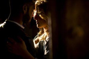 Con poca luz, una "Sesión fotográfica boudoir en pareja Málaga" captura un momento tierno, con una luz cálida resaltando el perfil de la mujer. - ForTwo - Planes para parejas