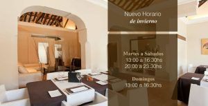 El elegante interior de Aire Gastrobar, con mesas y sillas con estilo, se complementa con una señalización en español que muestra el horario de invierno de la Cocina mediterránea de autor. - ForTwo - Planes para parejas
