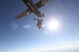 Los paracaidistas tándem disfrutan de una emocionante caída libre con Salto en paracaídas con Skydive Madrid, rodeados de cielos despejados y sol brillante, creando el escenario perfecto para una experiencia inolvidable. - ForTwo - Planes para parejas