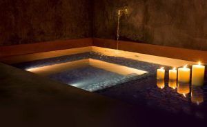 Experimente la tranquilidad de un Hammam en Rituels d'Orient Barcelona con el Ritual de los Sultanes, rodeado de una piscina resplandeciente, agua corriente y un ambiente iluminado con velas que captura la serenidad. - ForTwo - Planes para parejas