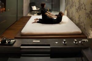 En el Mandarin Oriental Barcelona, alguien disfruta de un masaje de "Sensación de Serenidad" en una tranquila sala de spa con poca luz. - ForTwo - Planes para parejas