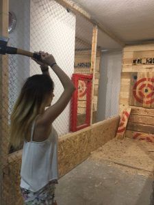En El Hachazo de Madrid, los visitantes participan en el emocionante arte del tiro con hacha, lanzando hachas con destreza a objetivos dentro de un campo de tiro interior asegurado por resistentes paredes de madera y redes. - ForTwo - Planes para parejas
