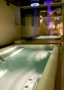 La piscina cubierta del Radisson Blu ofrece iluminación violeta y un techo elegante y reflectante que realza el ambiente lujoso de la experiencia del Circuito spa en Radisson Blu Prado. - ForTwo - Planes para parejas