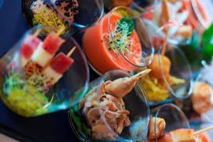 Una experiencia de lujo con tapas gourmet variadas, que incluyen brochetas y salsas, presentadas elegantemente sobre una superficie reflectante, similar a un Spa y masaje a lo japonés + menú de tapas en Madrid. - ForTwo - Planes para parejas
