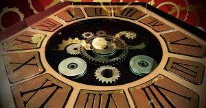 Primer plano de la esfera de un reloj antiguo adornado con números romanos y engranajes visibles, similares a los elementos cautivadores que encontrarás en Misión Oopart Escape Room Sevilla. - ForTwo - Planes para parejas