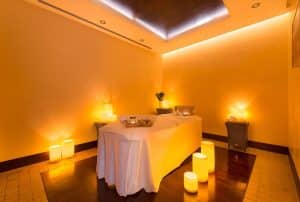 La sala de masajes, con luz tenue, velas y productos esenciales de spa, prepara el escenario para una experiencia rejuvenecedora en La Cala Golf Málaga. Complemente su visita con nuestro exclusivo Circuito de Hidroterapia en el Spa de La Cala Golf Málaga para una relajación total. - ForTwo - Planes para parejas
