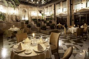 En el corazón del Centro, el Hotel Vincci Centro Granada ofrece un elegante restaurante con mesas iluminadas con velas, sillas de mimbre e iluminación ambiental en un espacioso entorno con paredes de ladrillo. - ForTwo - Planes para parejas