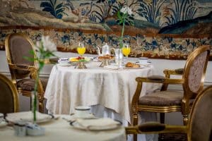 En el elegante comedor del Hotel Wellington Madrid, una mesa de desayuno adornada con zumo de naranja, pasteles y flores ofrece un delicioso comienzo del día. - ForTwo - Planes para parejas