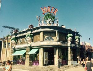 La Entrada con descuento al Parque Warner de Madrid cuenta con un edificio con temática del Joker, con grandes caras del Joker y una fachada vibrante que contrasta con el cielo azul claro de Madrid. - ForTwo - Planes para parejas