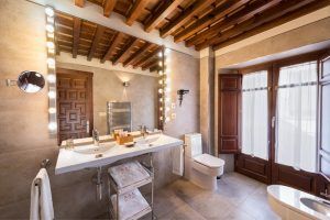 Experimente el encanto de un hotel boutique con lavabos dobles, un gran espejo luminoso, techo de madera y una ventana con cortinas transparentes que recuerda al Hotel Boutique Gar Anat Granada. - ForTwo - Planes para parejas