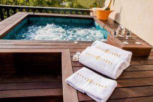 Experimente la tranquilidad en una serena terraza de madera en el Hotel Lobby Room Sevilla, que cuenta con un jacuzzi burbujeante, un balde de champán y toallas de marca: su escapada perfecta en este entorno lujoso. - ForTwo - Planes para parejas
