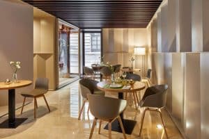Esta moderna cafetería, situada cerca del Hotel Posada del Lucero Sevilla, cuenta con mesas de madera, sillas grises y una puerta de vidrio que se abre a una encantadora zona al aire libre. - ForTwo - Planes para parejas