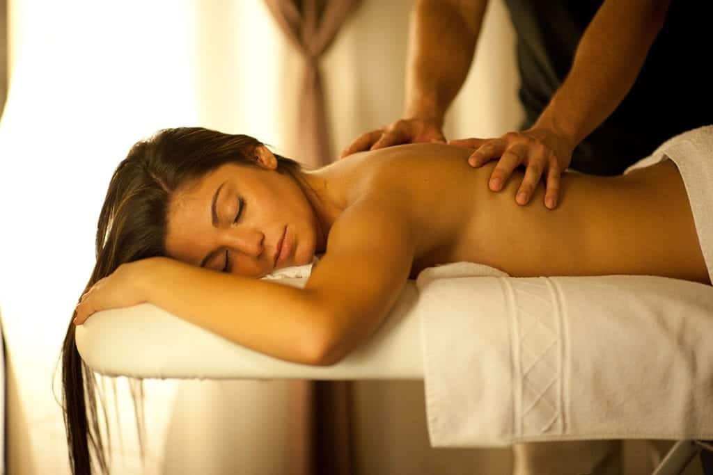 En Kumaras Spa en Umbrete, una persona se relaja con el Circuito spa con Masaje e infusión o zumo, con los ojos cerrados mientras está acostada en la camilla de masaje. - ForTwo - Planes para parejas
