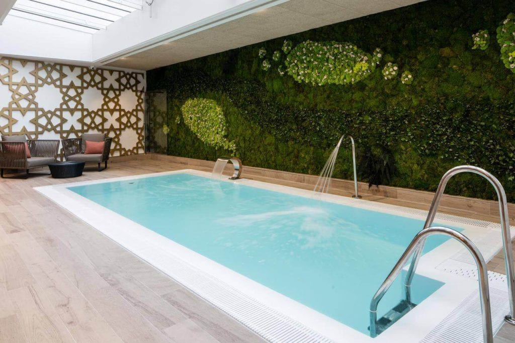 El Hotel Catalonia Giralda cuenta con una piscina cubierta con cascada, elegante suelo de madera y un llamativo jardín vertical. - ForTwo - Planes para parejas