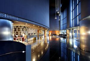 El elegante vestíbulo del Hotel Eurostars Madrid Tower cuenta con suelos negros brillantes, asientos elegantes y un mostrador de recepción geométrico. - ForTwo - Planes para parejas